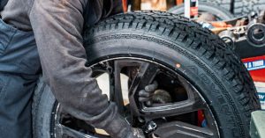 Close-up of a tyre being handled during a workshop inspection for tread wear